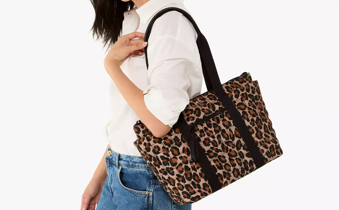 A Person wearing a Kate Spade Outlet Camden Spotted Leopard Medium Tote