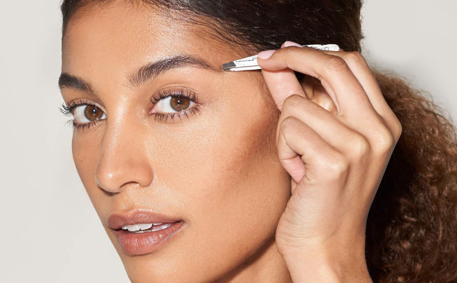 A Woman Using a Tweezerman Mini Slant Patterned Tweezer