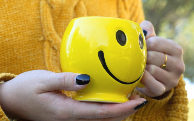 A Person Holding a Corner Bakery Cafe Smiley Mug A Person Holding a Corner Bakery Cafe Smiley Mug