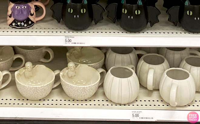 Hyde EEK Stoneware Skeleton in Latte Mug with Crackle and Stoneware Figural Pumpkin Mug on a Store Shelf Hyde EEK Stoneware Skeleton in Latte Mug with Crackle and Stoneware Figural Pumpkin Mug on a Store Shelf