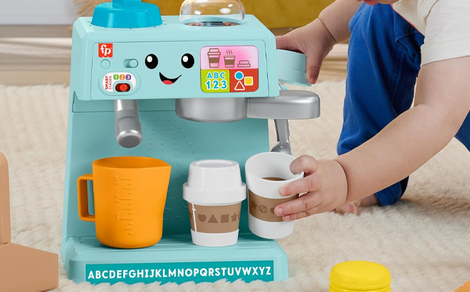 A Boy Playing with the Fisher Price Laugh Learn Coffee Cafe Musical Playset A Boy Playing with the Fisher Price Laugh Learn Coffee Cafe Musical Playset