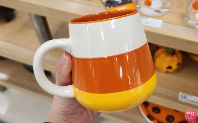 A Woman Holding Hyde Eek Stoneware Candy Corn Mug