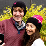 People Wearing T Mobile Beanies while Looking at a Phone