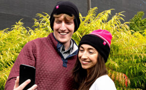 People Wearing T Mobile Beanies while Looking at a Phone