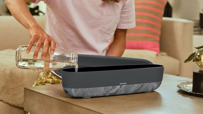 a Person Using HoMedics Fireside Plus Gal Top Fill Ultrasonic Humidifier