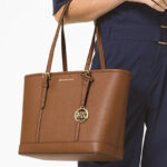 A Person Holding Michael Kors Jet Set Travel Small Saffiano Leather Top Zip Tote Bag