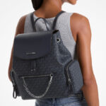 A Person Holding Michael Kors Outlet Jet Set Large Signature Logo Backpack