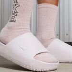 A Person Wearing Nike Womens Nike Calm Slide Sandals