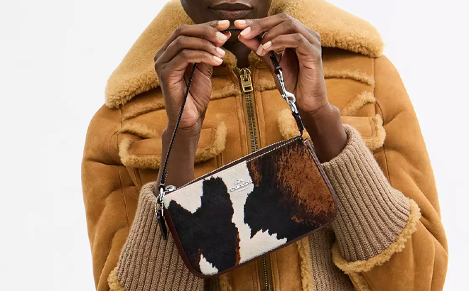 A Woman Holding Coach Outlet Nolita 19 with Cow Print