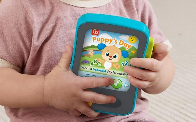 A baby Holding a Fisher Price Pretend Tablet