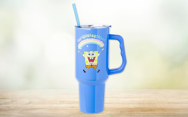 Silver Buffalo 40 Ounce SpongeBob SquarePants Stainless Steel Tumbler with Handle and Straw on a Table Silver Buffalo 40 Ounce SpongeBob SquarePants Stainless Steel Tumbler with Handle and Straw on a Table