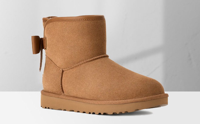 UGG Womens Ultra Mini Bailey Leather Bow Boot in Chestnut Color on the Table