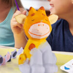 A Child painting a Deer Lamp
