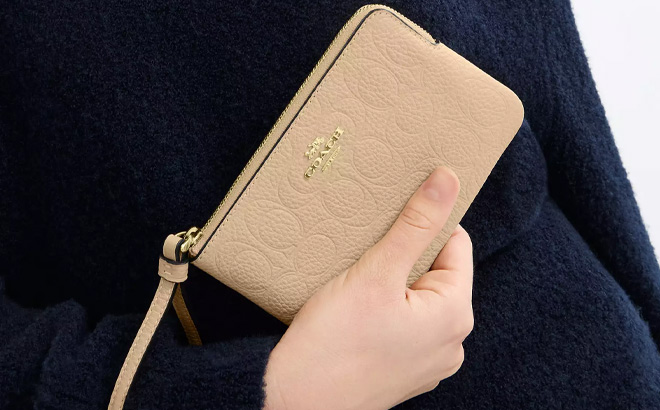 A Person Holding Coach Outlet Corner Zip Wristlet in Pebbled Leather