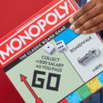 A Person Holding a Monopoly Board Game
