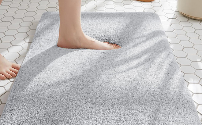 A Person Stepping on a Minidear Bathroom Rug