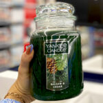 A Person holding a Yankee Candle Large Candle in Balsam and Cedar Scent