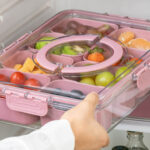 A Person putting a Cook With Color Snackle Box into a Fridge
