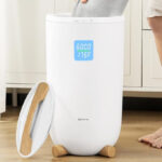 A Person putting a Towel into a Keenray Large Towel Warmer Bucket