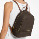 A Woman Wearing Michael Kors Rhea Medium Signature Logo Backpack