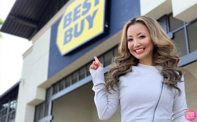 A Woman Standing in Front of a Best Buy Store Pointing at the Store Sign