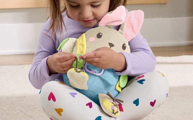 A Kid Holding Fisher Price Toddler Educational Toy Learn to Dress Bunny Plush A Kid Holding Fisher Price Toddler Educational Toy Learn to Dress Bunny Plush