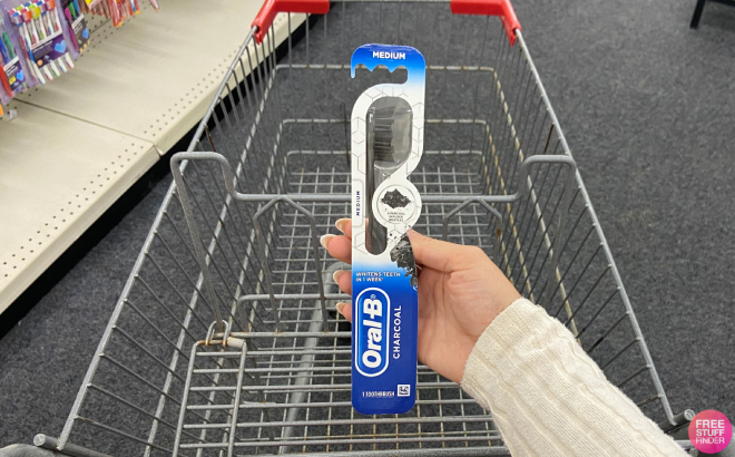 A Person Holding an Oral B Charcoal Totthbrush A Person Holding an Oral B Charcoal Totthbrush