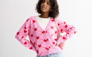 A Person Wearing FOREVER EVER Long Sleeve Heart And Bow Button Front Sweater