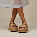 A Person Wearing UGG GoldenGlow Slide Platform Sandals