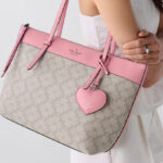 A Person Wearing the Kate Spade All Day Spade Flower Tote Bag With Charm