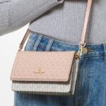 A Person wearing Michael Kors Jet Set Small Two Tone Logo Smartphone Crossbody Bag
