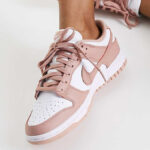 A Person wearing Nike Dunk Low Womens Shoes in Rose Whisper Color