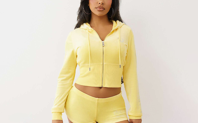 A Person wearing True Religion Velour Crystal Zip Hoodie in Lemon Drop Color