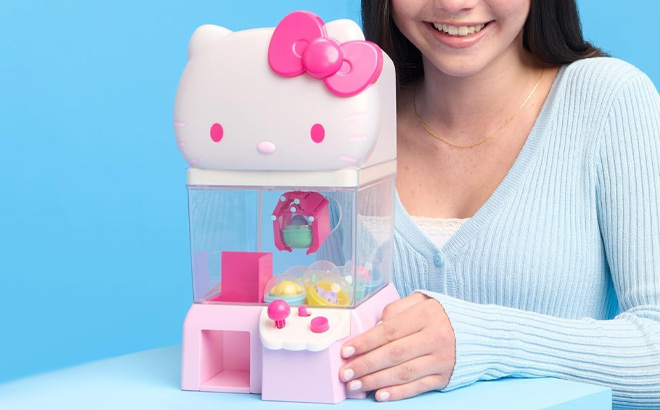A Person Holding Jazwares Hello Kitty and Friends Claw Machine with 8 Collectible Mini Figures