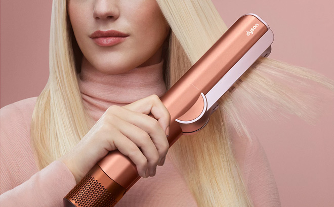 A Person Using a Dyson Amber Silk Airstrait Wet to Dry Straightener