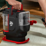 A Person using Dirt Devil Portable Spot Cleaner