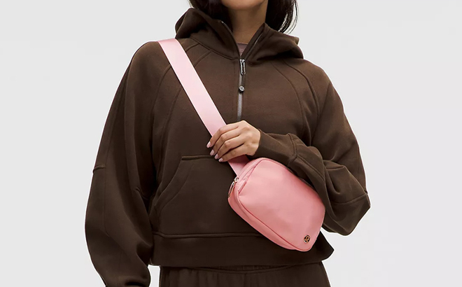 A Person wearing Lululemon Everywhere Belt Bag 1L in Tea Rose Color A Person wearing Lululemon Everywhere Belt Bag 1L in Tea Rose Color