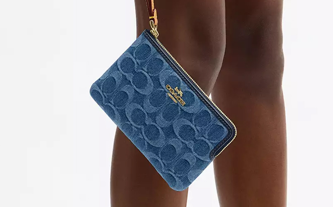 A Woman Holding Coach Outlet Corner Zip Wristlet In Signature Denim A Woman Holding Coach Outlet Corner Zip Wristlet In Signature Denim