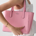 A Woman Wearing Kate Spade Staci Tote Bag in Grapefruit Soda