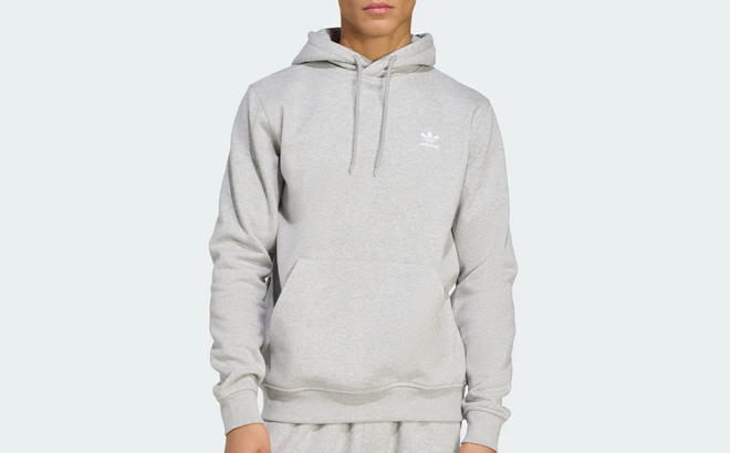 A Man Wearing Adidas Trefoil Essentials Hoodie in Medium Grey Heather
