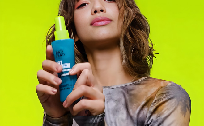 A Person Holding a Spray Bottle of TIGI Bed Head Spray A Person Holding a Spray Bottle of TIGI Bed Head Spray