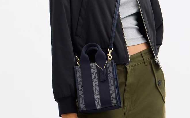 A Woman Wearing Coach Outlet Smith Mini Tote Bag In Signature Jacquard in Navy