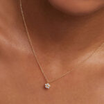 A Woman Wearing Zales Cubic Zirconia Daisy Pendant in Sterling Silver with 18K Gold Plate