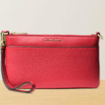 Michael Kors Jet Set Medium Pebbled Leather Wristlet in Crimson on a Table