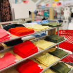 Tops on a Shelf at Target Next to a Cart