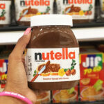 A Person Holding Nutella Hazelnut Spread with Cocoa Jar