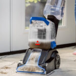 A Person Using Bissell TurboClean Powerbrush Carpet Cleaner