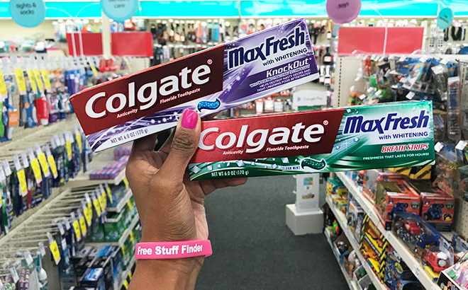 A Person Holding Two Colgate Toothpastes