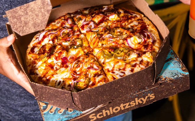A Person Holding a Schlotzskys Pizza