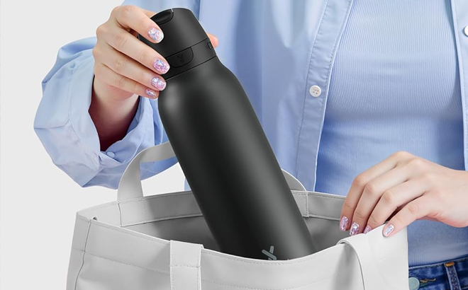 A Woman Holding Meoky 24 Ounce Slim Insulated Water Bottle in Black